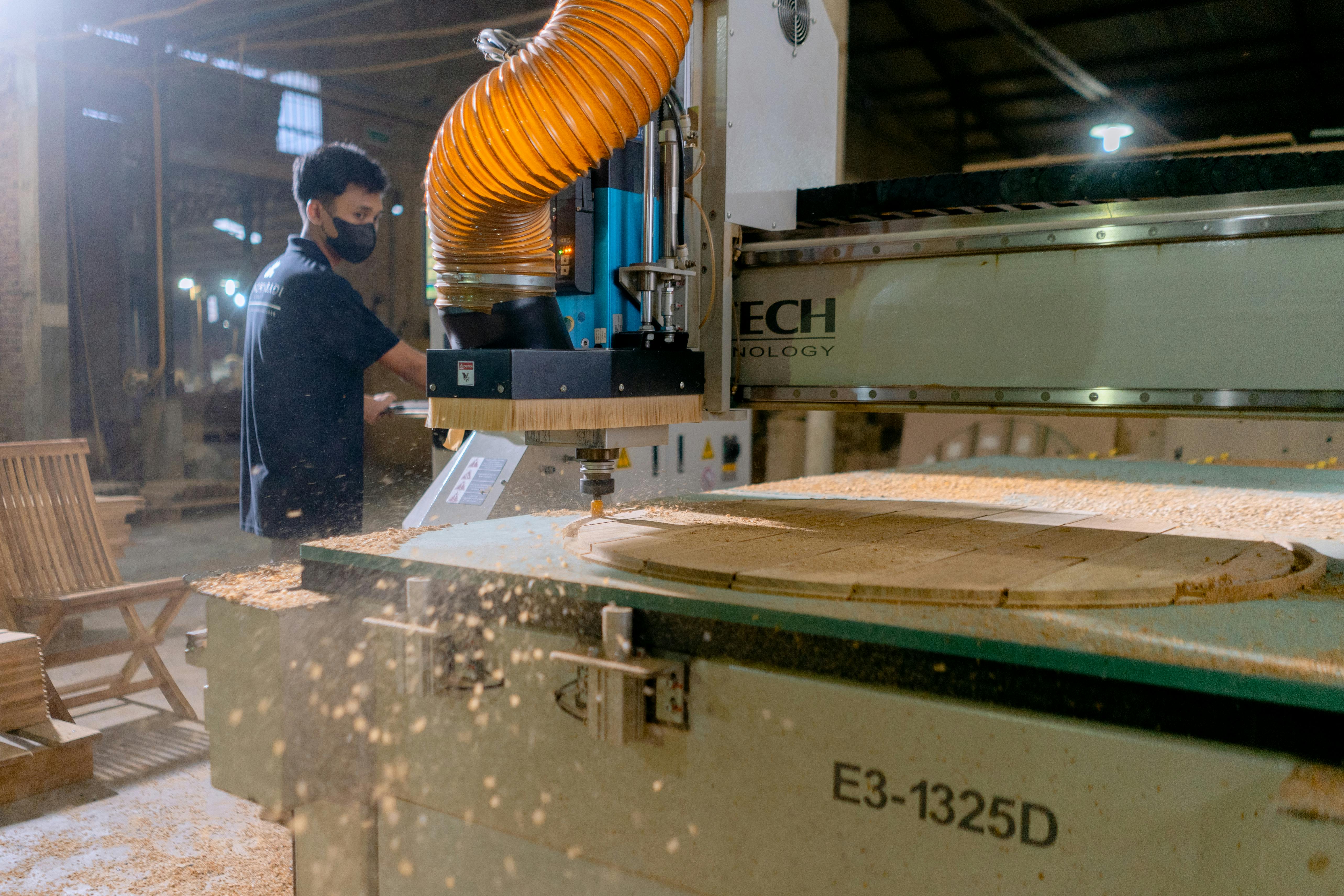pexels photo 15016508 15016508 A carpenter operates a CNC machine in a factory, showcasing modern woodworking technology.
